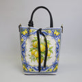 Borsa a secchiello in pelle bianca con stampa limoni e decori maiolica blu