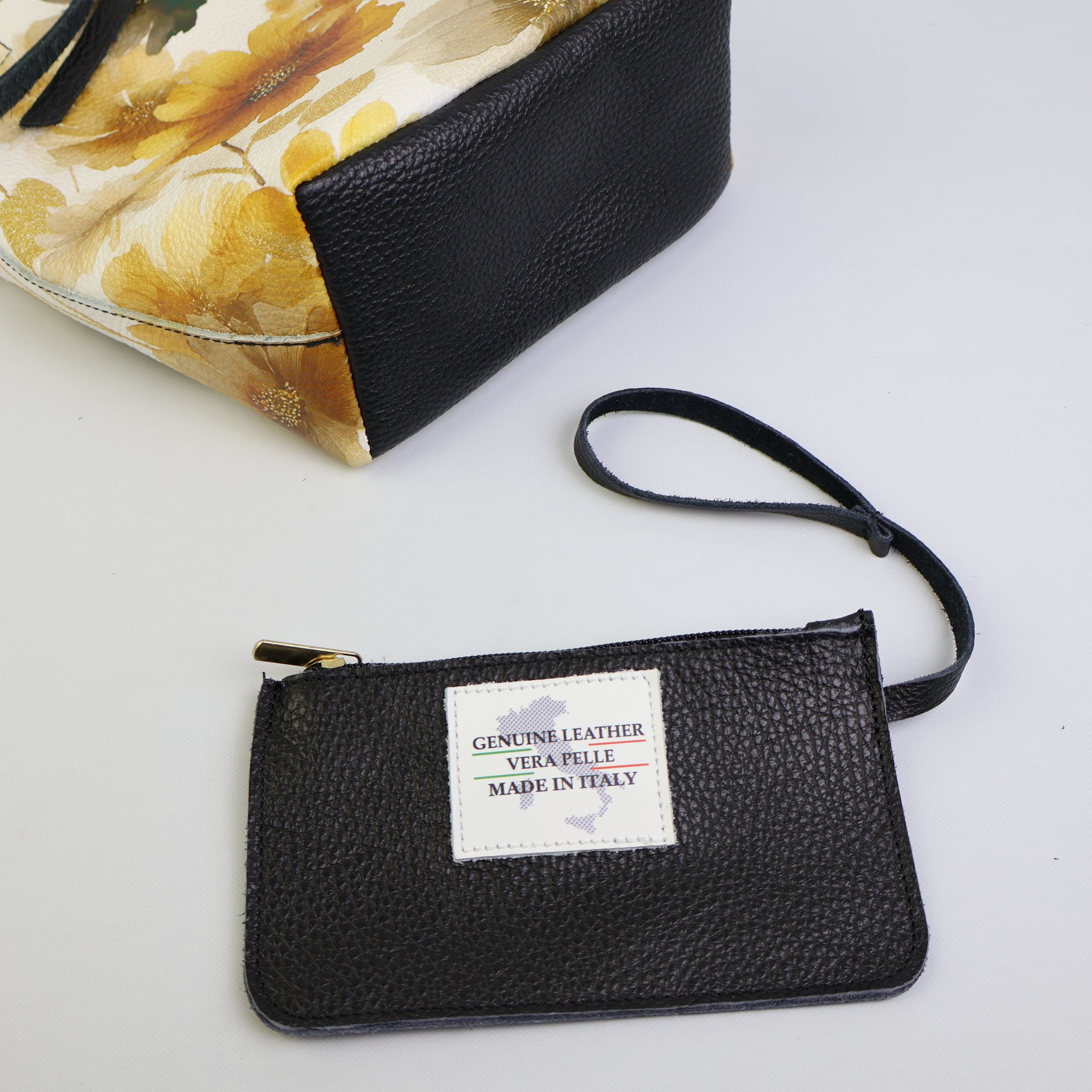 Pochette nera in vera pelle con zip e laccetto da polso inclusa nella borsa tote floreale